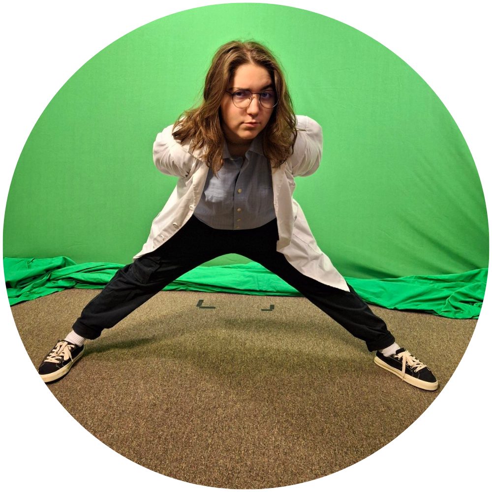 Photograph of Kate LeVine posing in front of a green screen.