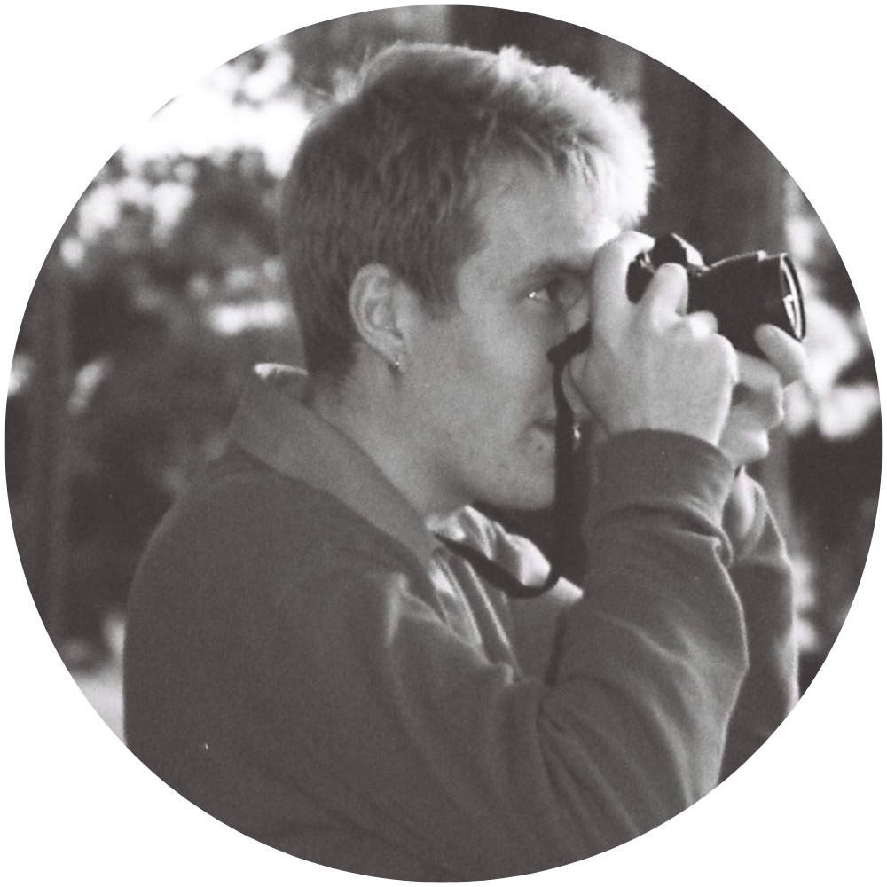 Profile style photograph of Keegan Douglass using a camera.